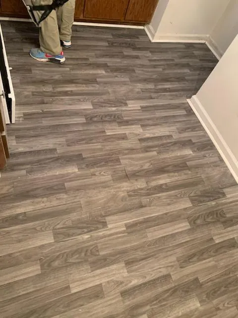 Gray wood look plank flooring installed at a kitchen entry